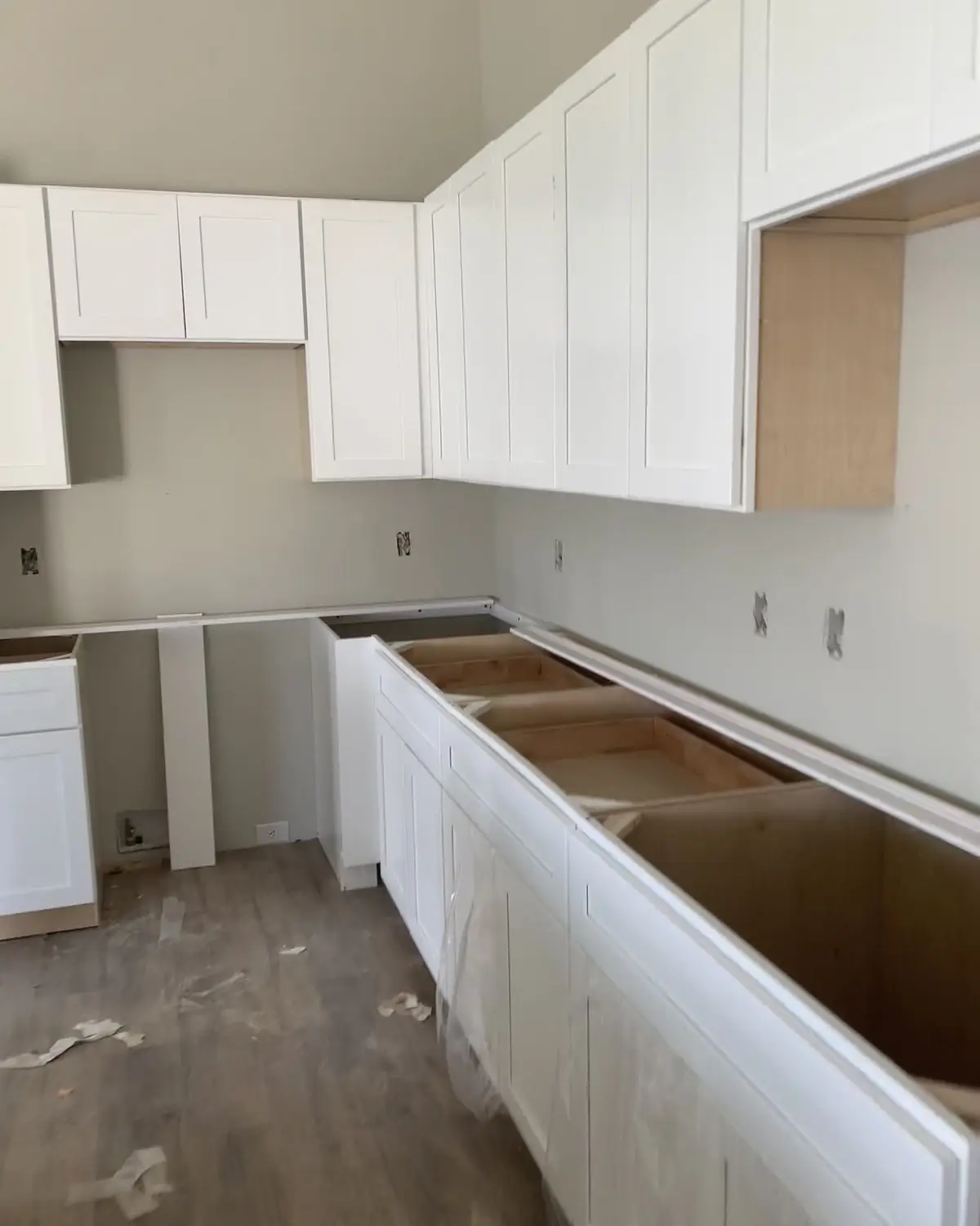 White shaker kitchen cabinets being installed, base cabinets set and ready for the countertop