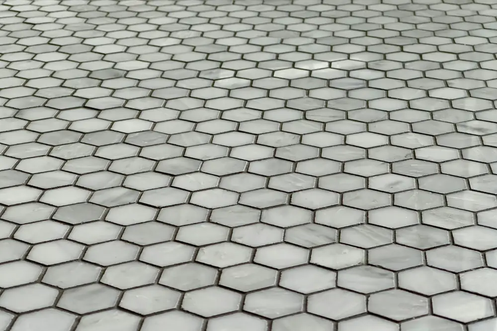 Close up of a hexagon marble mosaic tile floor with even gray grout lines